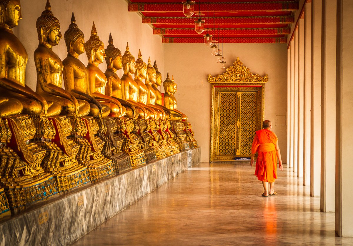 A monk by golden statues