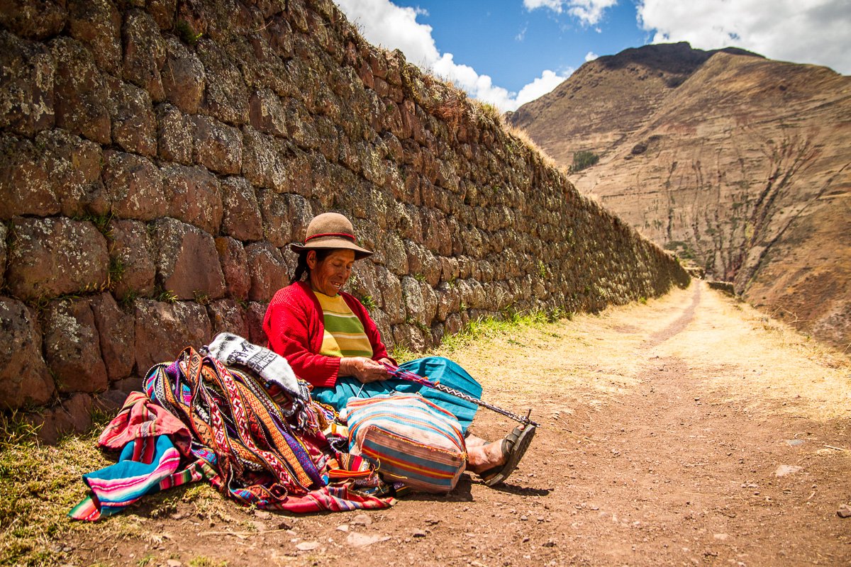 Peruvian woman by Inka ruins working